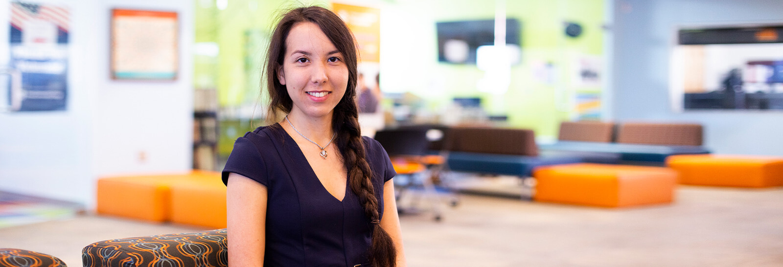 Kira Okuma Poses smiling in Pima's Northwest Campus Student Life Center