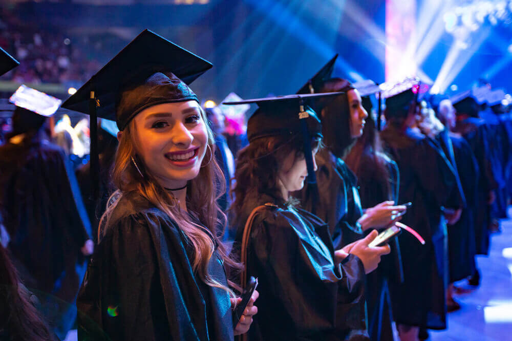 Student smiles for the camera at commencement.