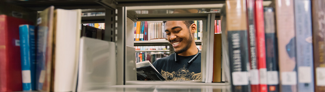 A student looks at a book in a Pima Library