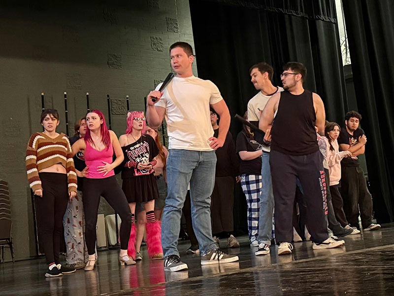Cast of the Urinetown musical on stage in the proscenium theater at PCC.