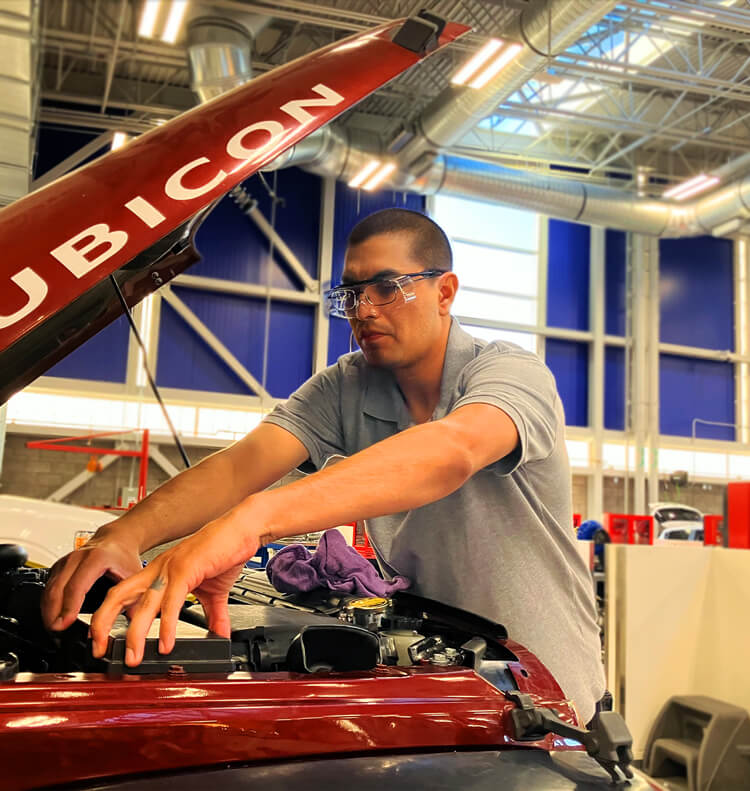 Fernando Romero works on a car engine at Pima's Automotive Technology Center.