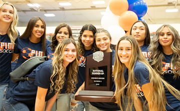 The Women's soccer team pose with their trophy