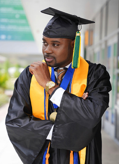 Webster Rose stands in a Cap and Gown