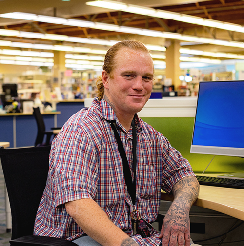 Peter Keith sits at a workstation in Downtown Campus's Library