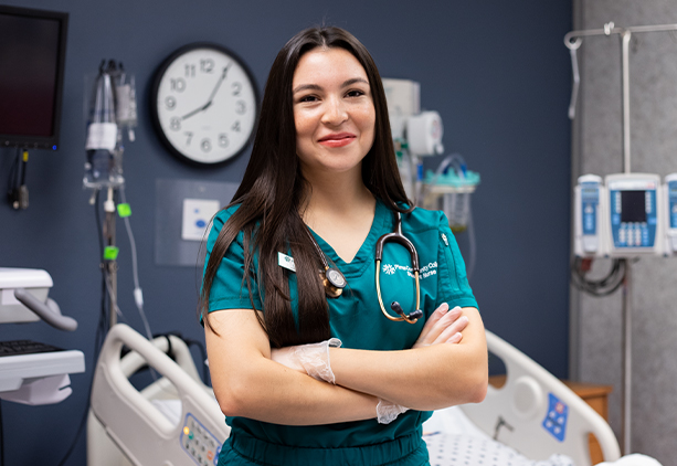 Lizbeth Mora Stands smiling in a nursing classroom