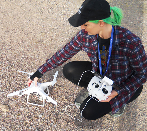 A student works on getting a drone ready to shoot footage in the desert