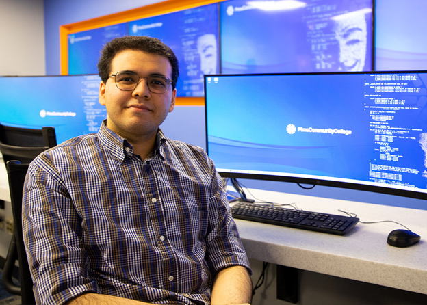 An IT student sits at a computer in the Cyber Security Center for Excellence