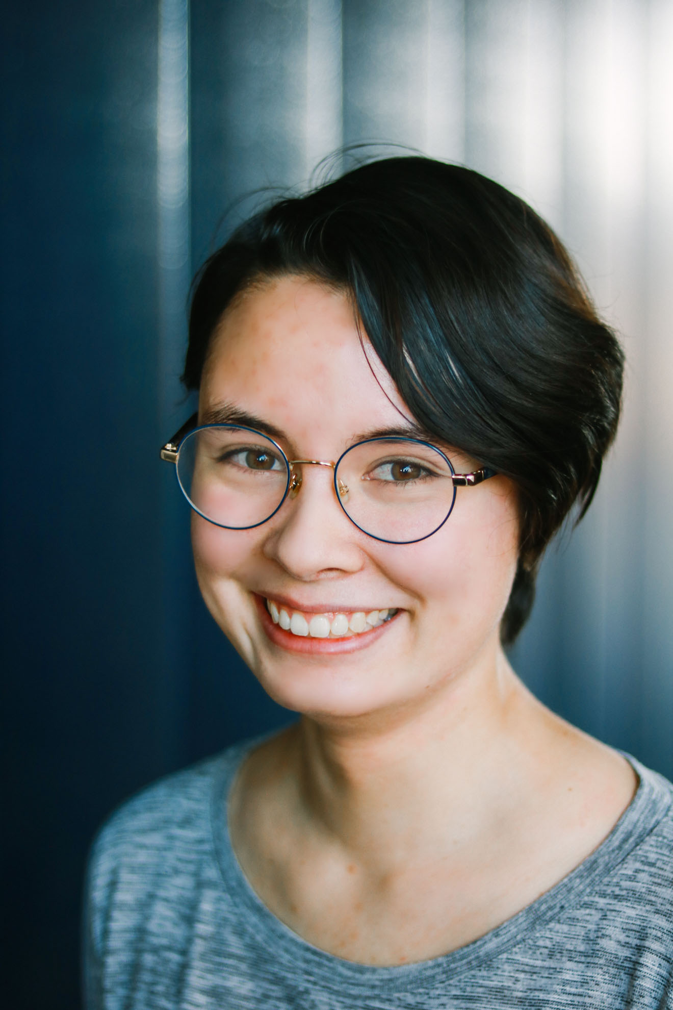 Headshot of Dana with short brown hair and glasses