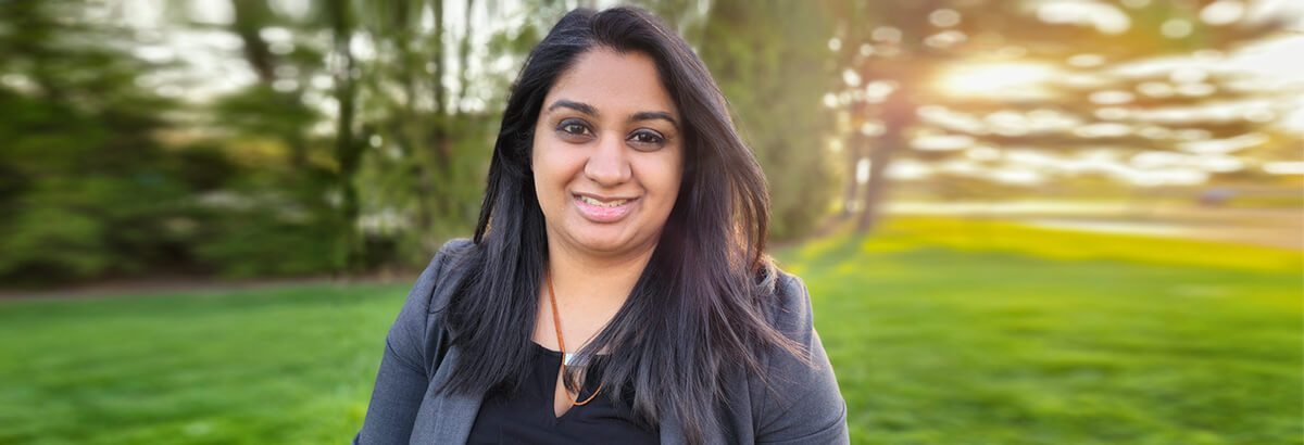 Namrata Patel poses smiling in a field at sunset