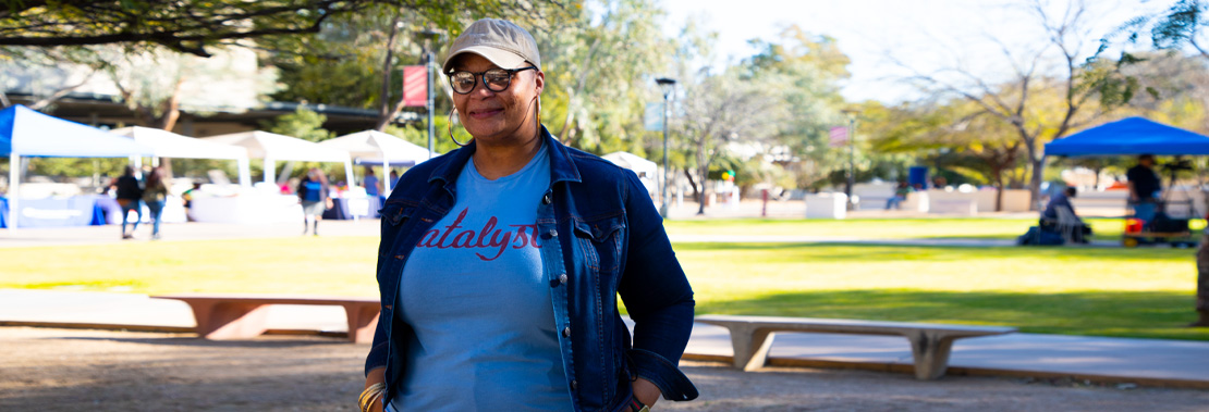 Treya Allen stands smiling in front of a Black History Month Event at Downtown Campus