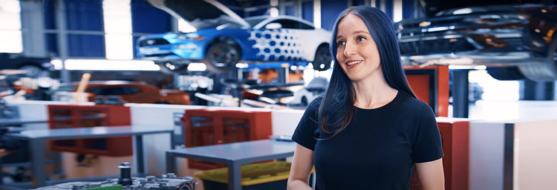 Alice stands facing the camera in Pima's Automotive Technology Center