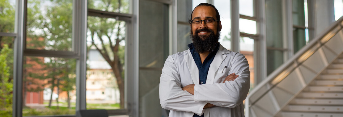 Jorge Muñoz stands in the lobby of the Health Science Center at NAU