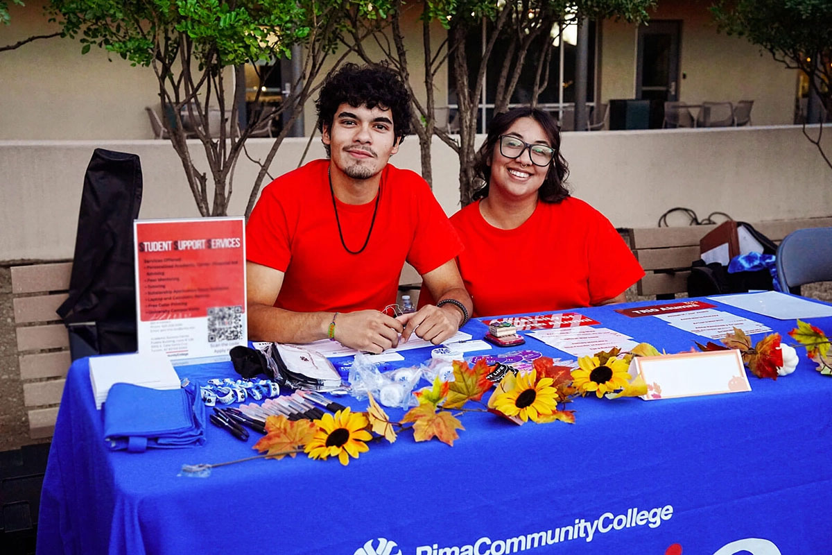 Volunteers at a table during a student welcome event.