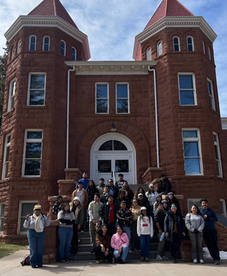 Trio students stand in front of a large academic building
