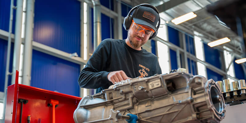 A male student works intently on a vehicle at PIma's Automotive Technology and Innovation Center.