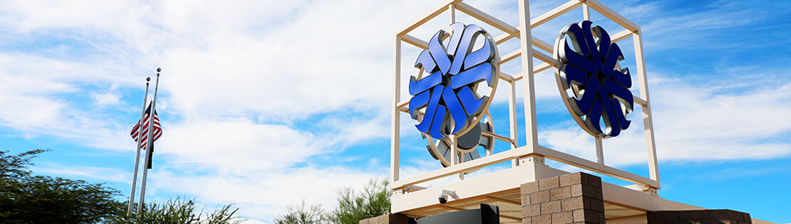An outside image of the Pima Logo tower at Pima East Campus