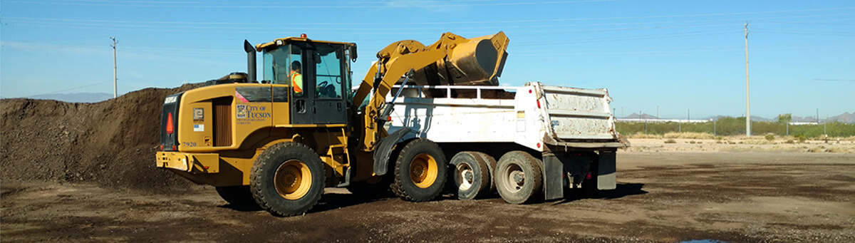 A Large front loader works in an empty lot in Tucson