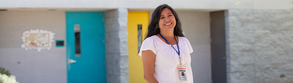 A Pima Faculty Member smiles in a courtyard at a Pima Adult Learning Center