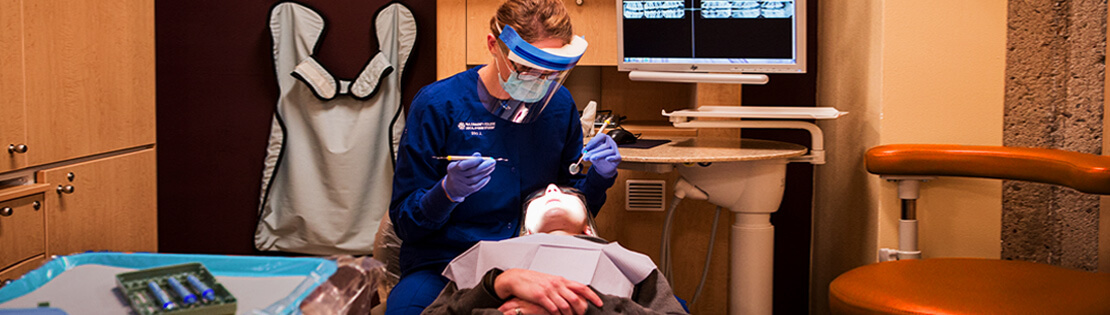 Dental hygiene student examines teeth of a patient