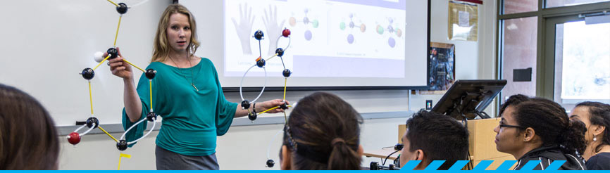 PCC Chemistry teacher holds model in classroom
