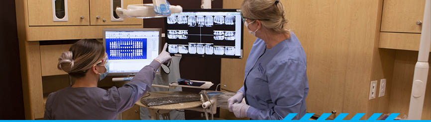 2 dental students looking at x-rays of teeth