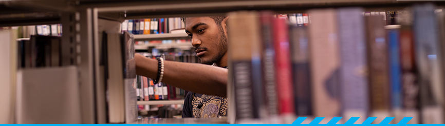Student in the library stacks at Desert Vista campus library