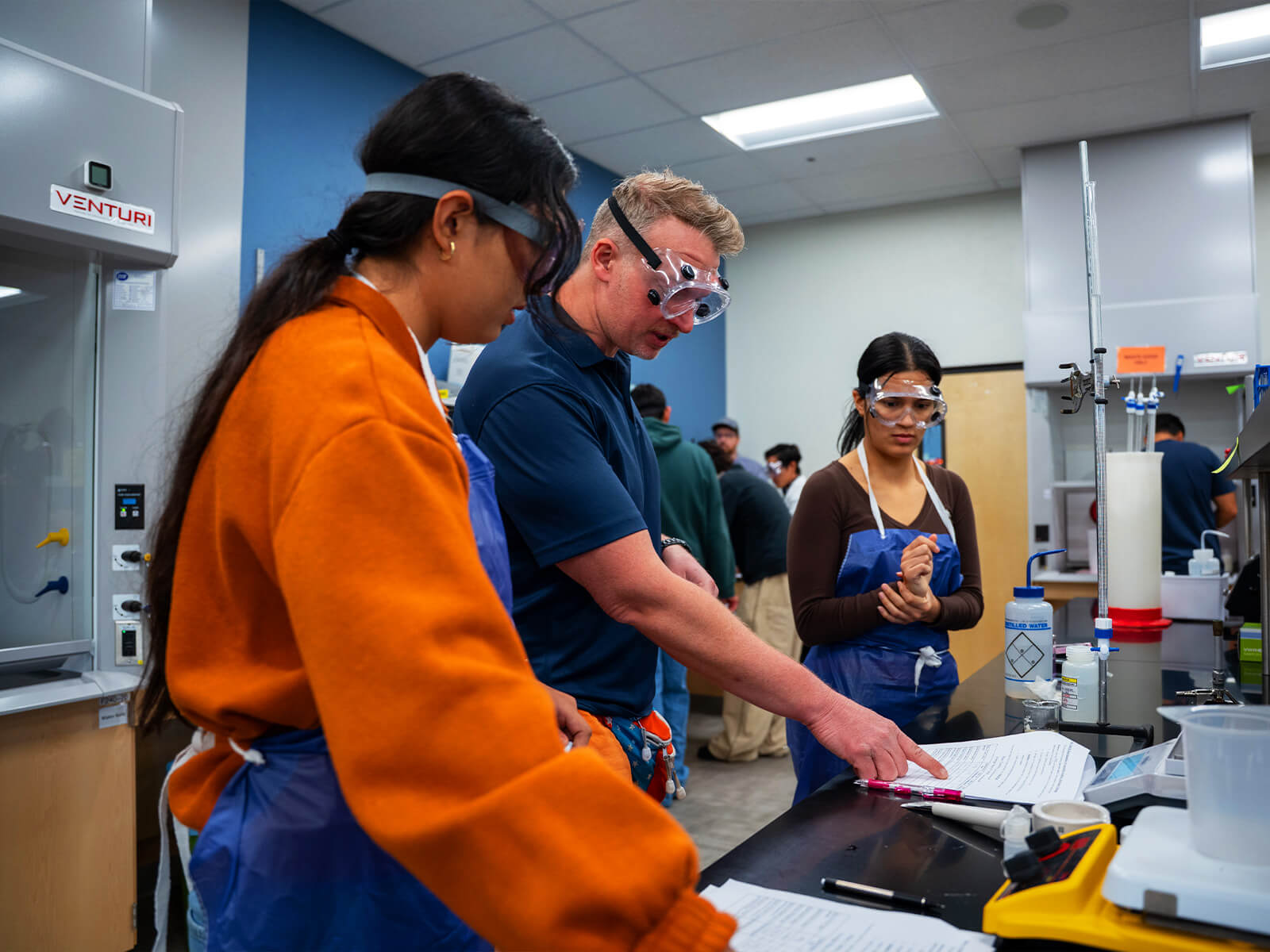 Students work with a teacher in a science lab