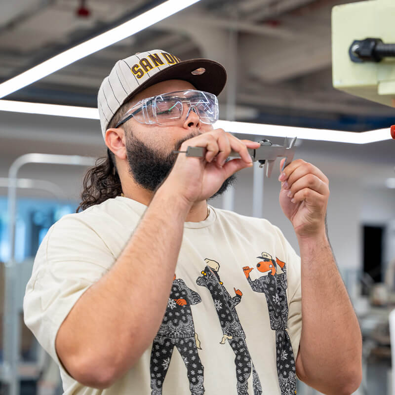 Antoni works on a machine in the machine tool lab